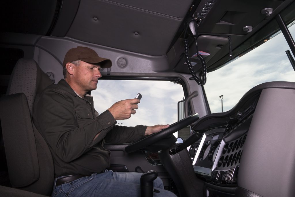 Distracted truck driver texting behind the wheel